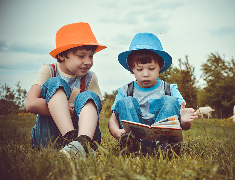 2 kinderen lezend in het gras