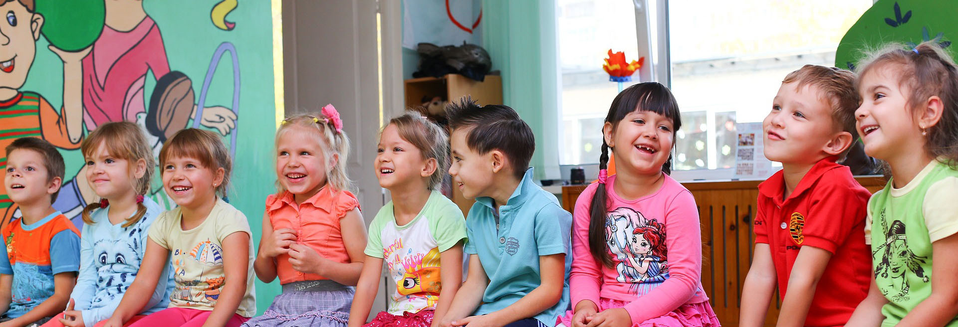 kleuters zitten op stoeltjes in een rij in de klas